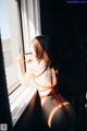 A woman in a bikini looking out a window.