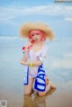 A woman in a straw hat is sitting in the water.