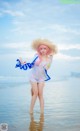 A woman in a straw hat standing in the water.