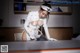 A woman in a white uniform is sitting at a desk.