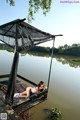 A woman laying on a dock next to a body of water.