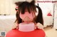 A little girl in a cat mask drinking milk from a bowl.