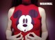 A woman wearing a red shirt with a mickey mouse face on it.