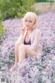 A woman sitting in a field of purple flowers.