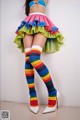 A woman in a colorful skirt and stockings posing for a picture.