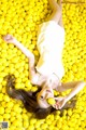 A woman laying in a field of yellow lemons.