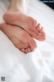 A close up of a person's feet on a bed.