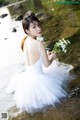 A woman in a white dress holding a bouquet of flowers.