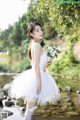 A woman in a white dress holding a bouquet of flowers.