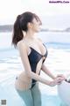 A woman in a black bathing suit standing in a pool.