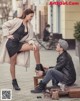 A man and a woman sitting on a bench in the street.