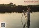 A woman standing on top of a wooden post next to a lake.