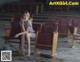 A woman sitting in an empty auditorium with a mop.