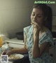 A woman sitting at a table eating a piece of food.