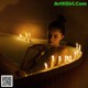 A woman sitting in a bathtub surrounded by candles.