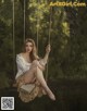 A woman sitting on a swing holding a book.