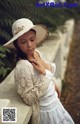 A woman in a white dress and a straw hat.