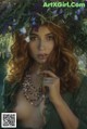 A woman with long red hair wearing a wreath of flowers.