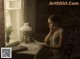 A woman sitting at a table reading a book.