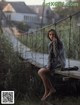 A woman sitting on a swing on a wooden bridge.