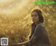 A woman sitting in a field of tall grass.