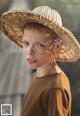 A young boy with freckles wearing a straw hat.