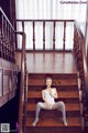 A woman sitting on the stairs of a house.