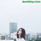 A woman standing on top of a roof next to a building.