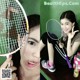 A woman holding a badminton racket in front of her face.