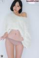 a woman in a white sweater and panties posing for a picture