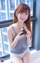 A woman sitting on a window sill holding a piece of seaweed.