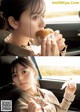 A woman sitting in a car eating a hamburger.