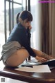 A woman sitting at a desk talking on a cell phone.