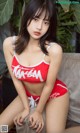 A woman in a red and white bikini sitting on a couch.